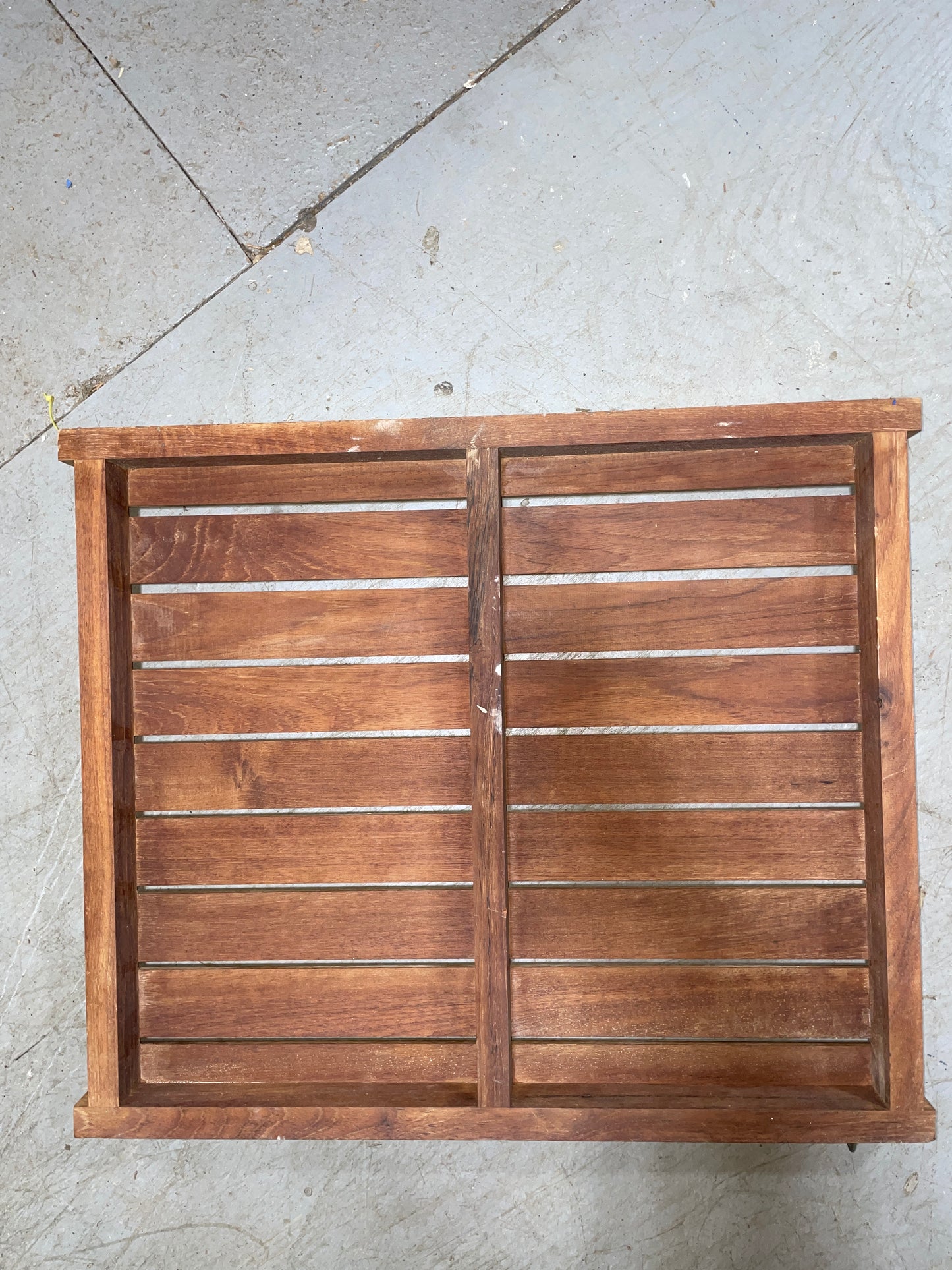 Wooden panel with slats on a concrete floor