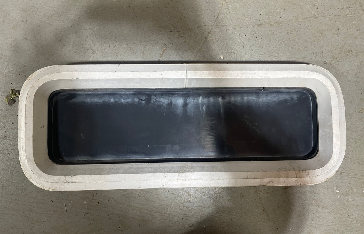 Rectangular metal container with a lid on a gray surface