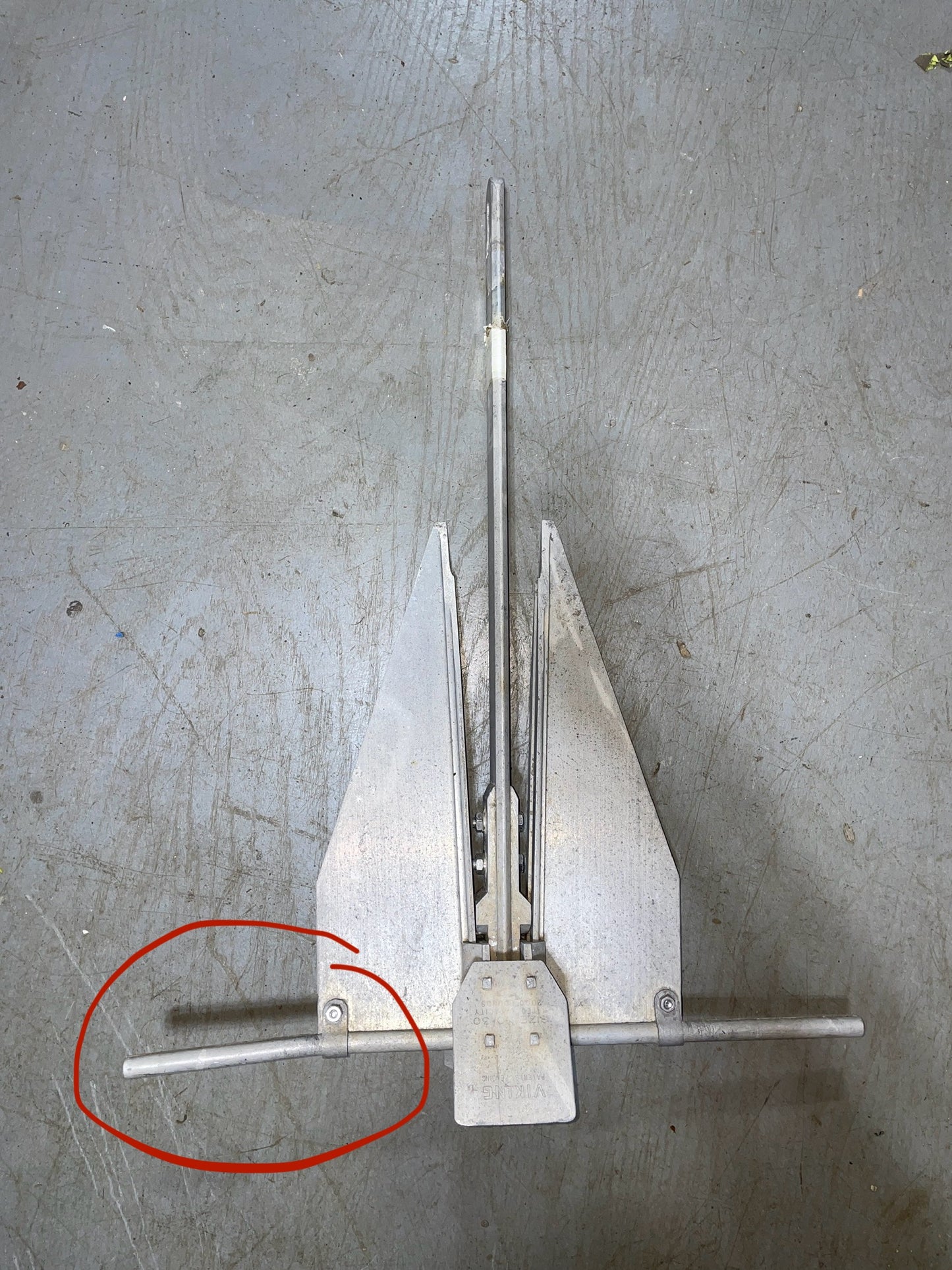 Metal tool or device on a metallic surface with a red circle highlighting a specific part.