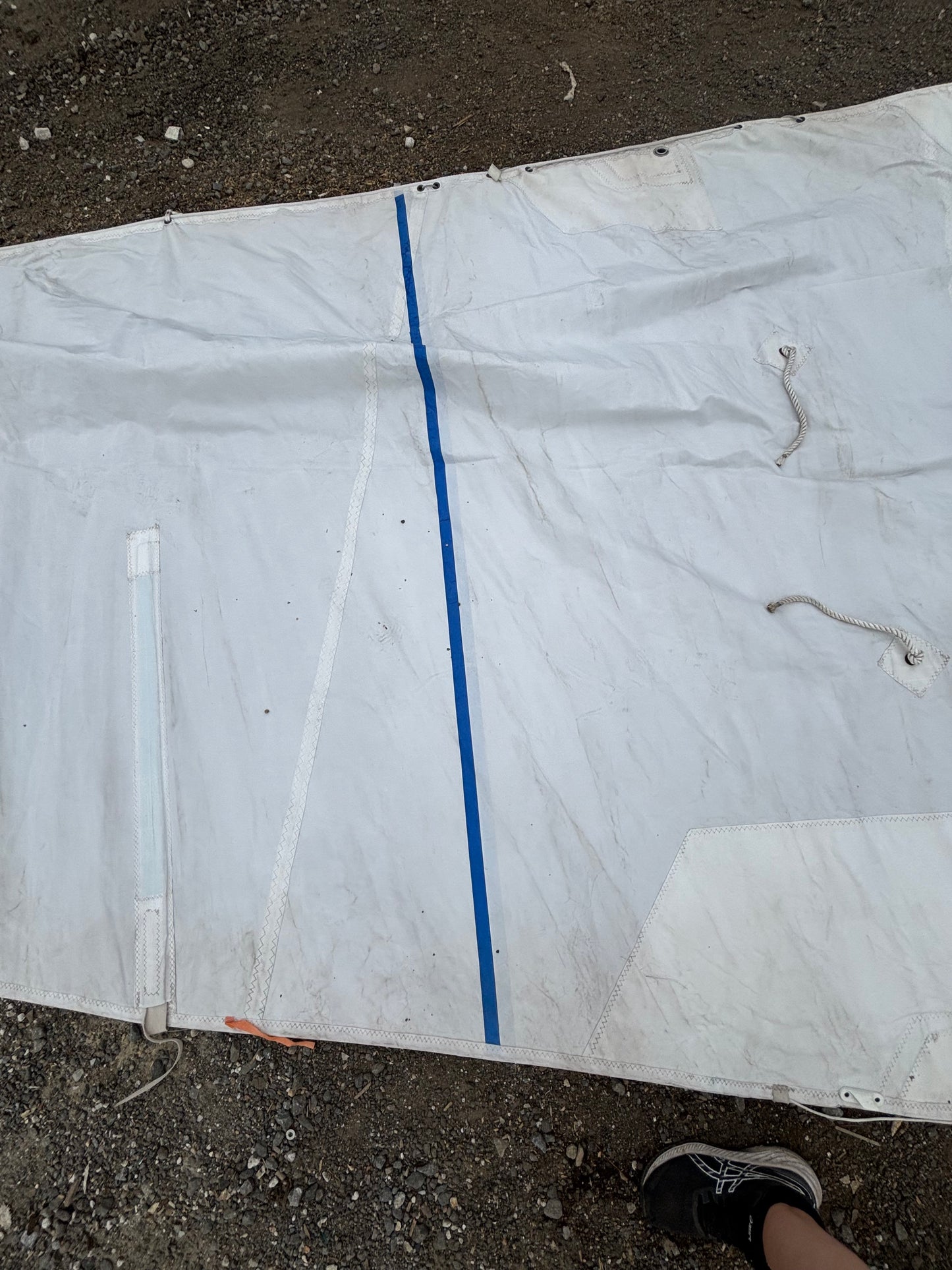 White plastic sheet with blue stripe on a concrete surface