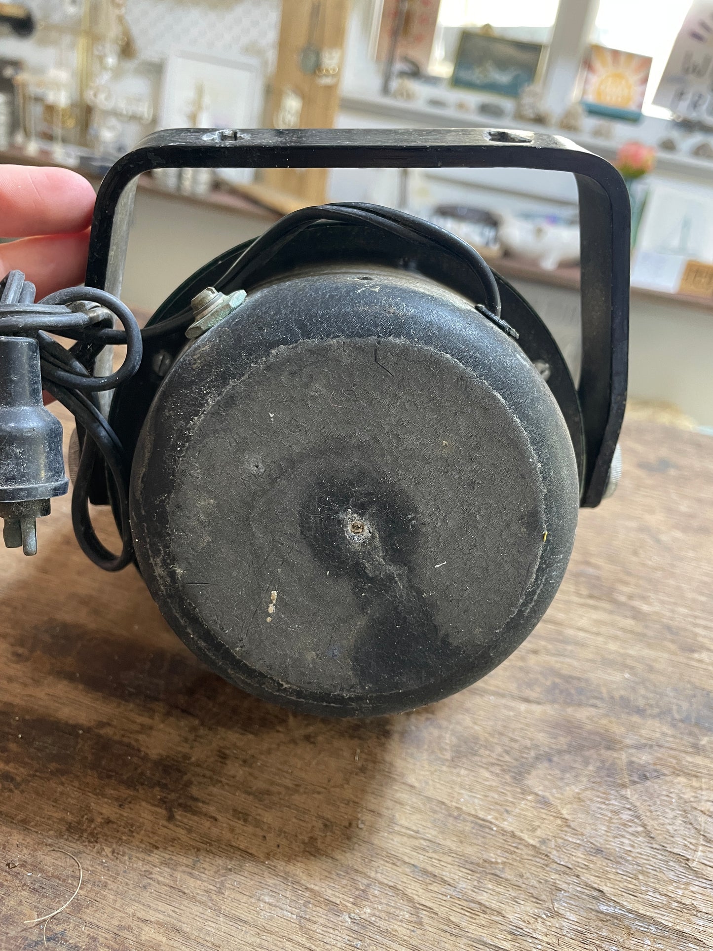 Black metal object with a cylindrical component on a wooden surface