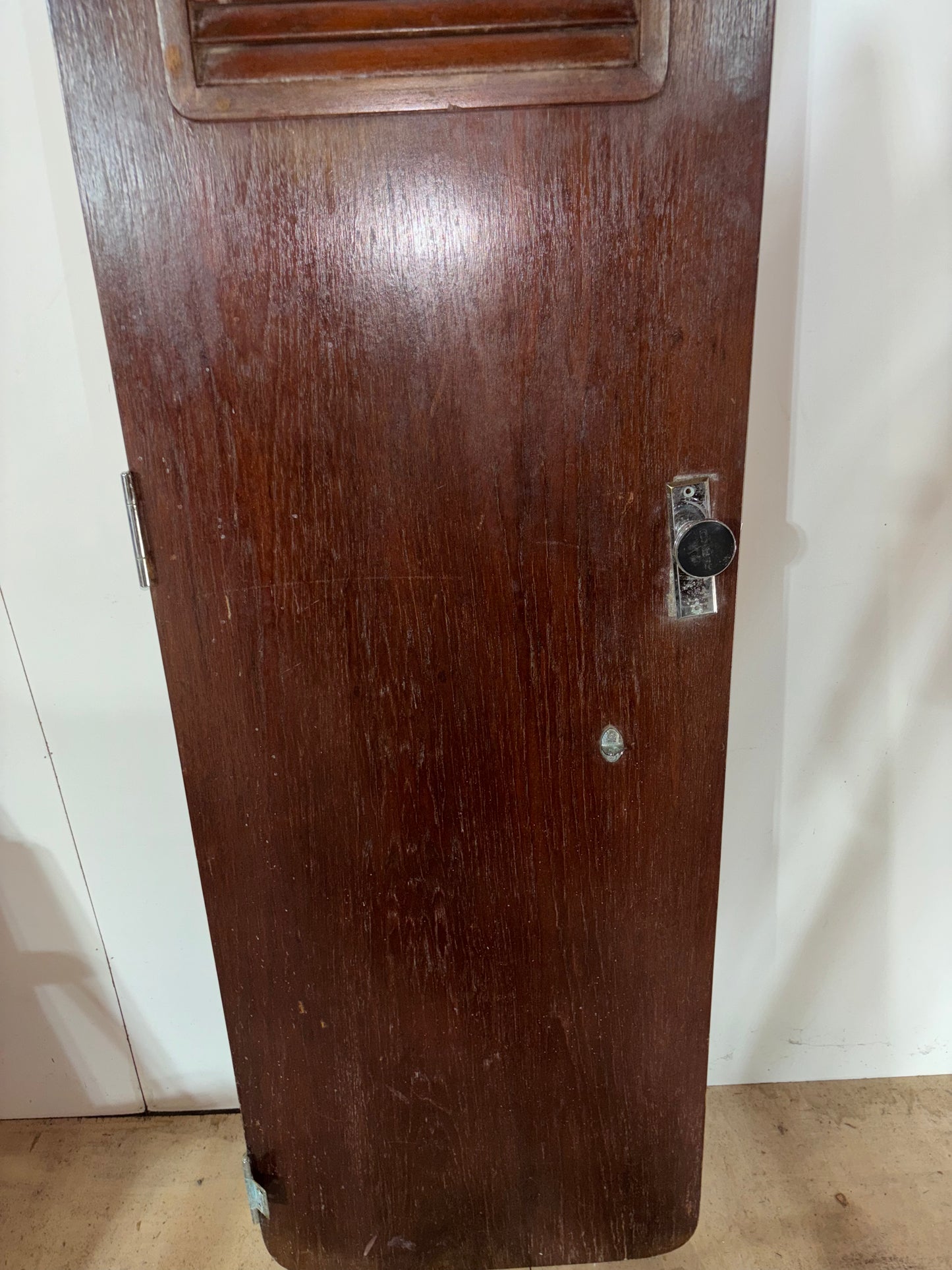 Dark wooden panel with a metallic handle on a white background
