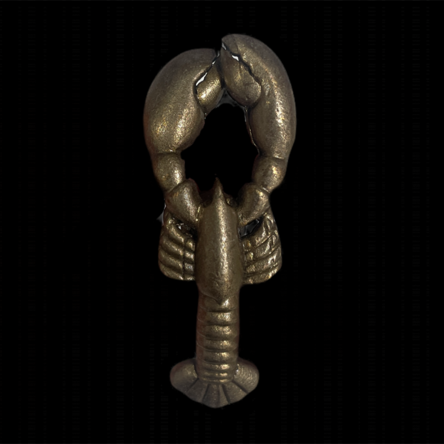 Metallic lobster charm on a black background