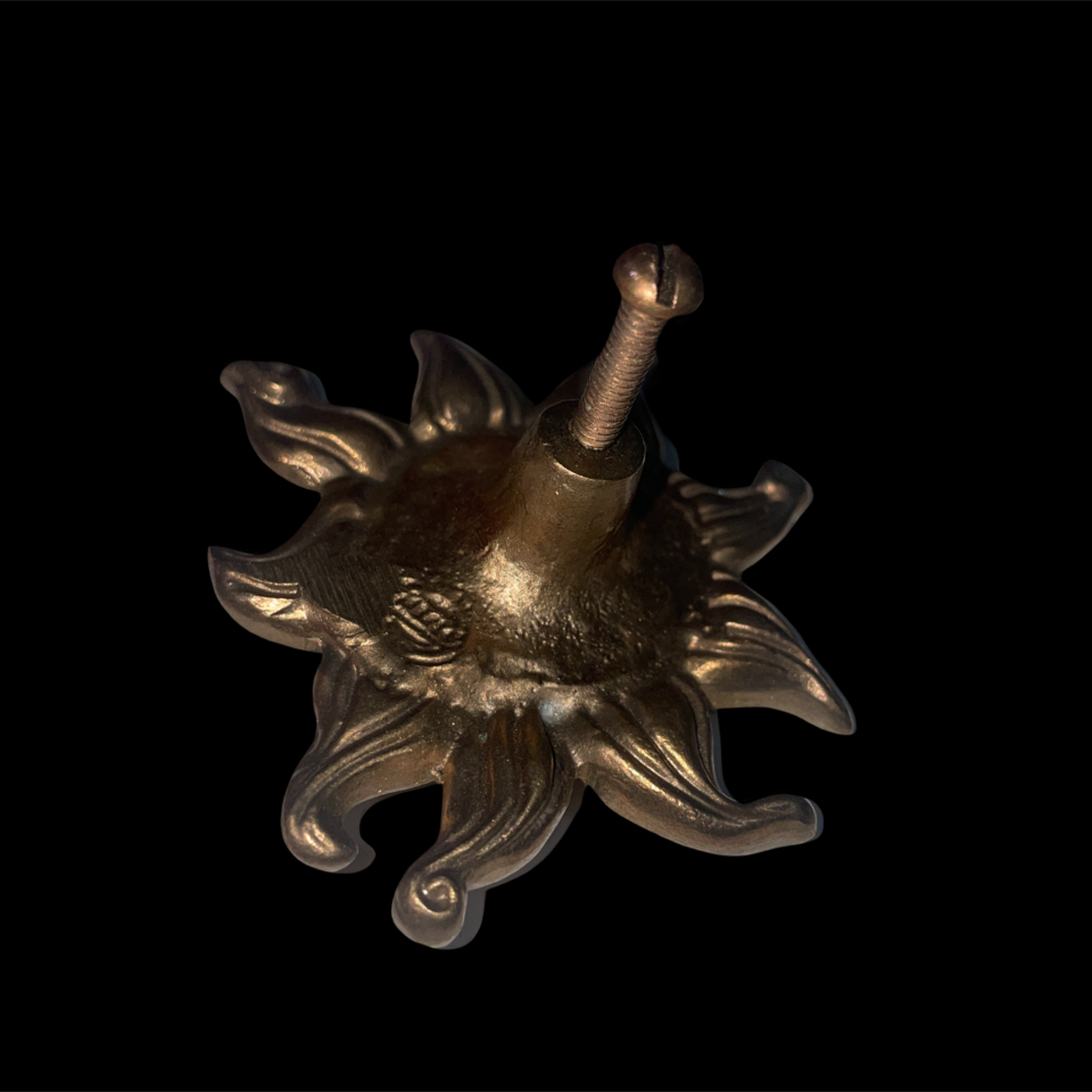 Decorative metal sun-shaped object on a black background