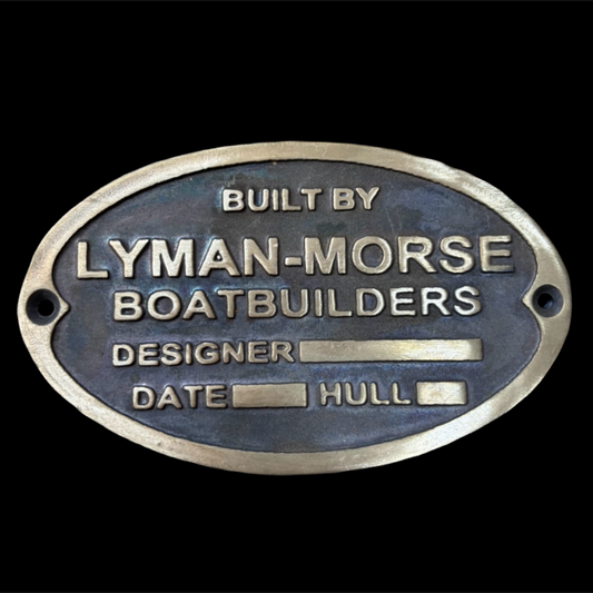 Metal plaque with 'Lyman-Morse Boatbuilders' text on a black background