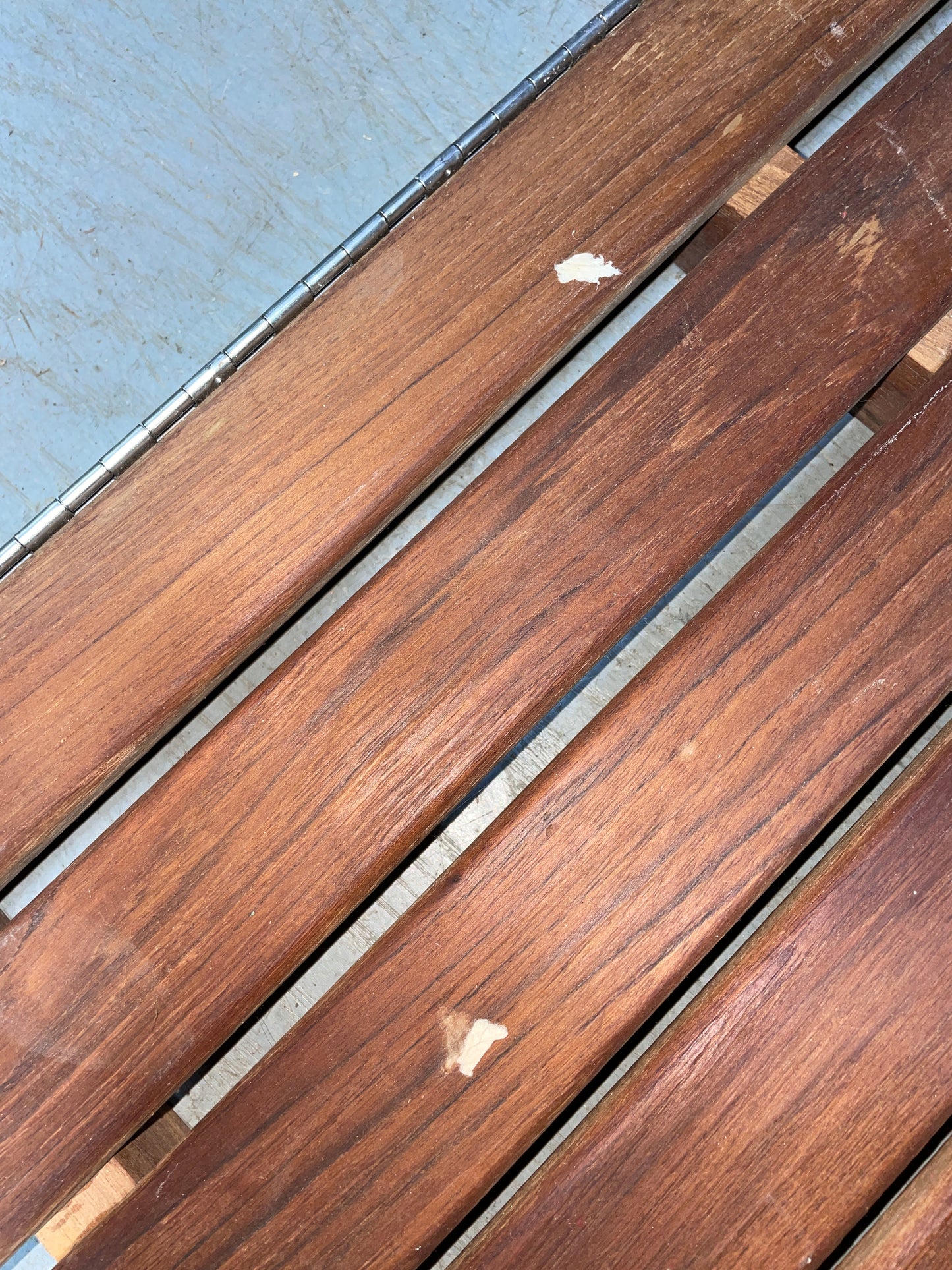 Wooden deck boards with visible grain and slight damage on a concrete surface
