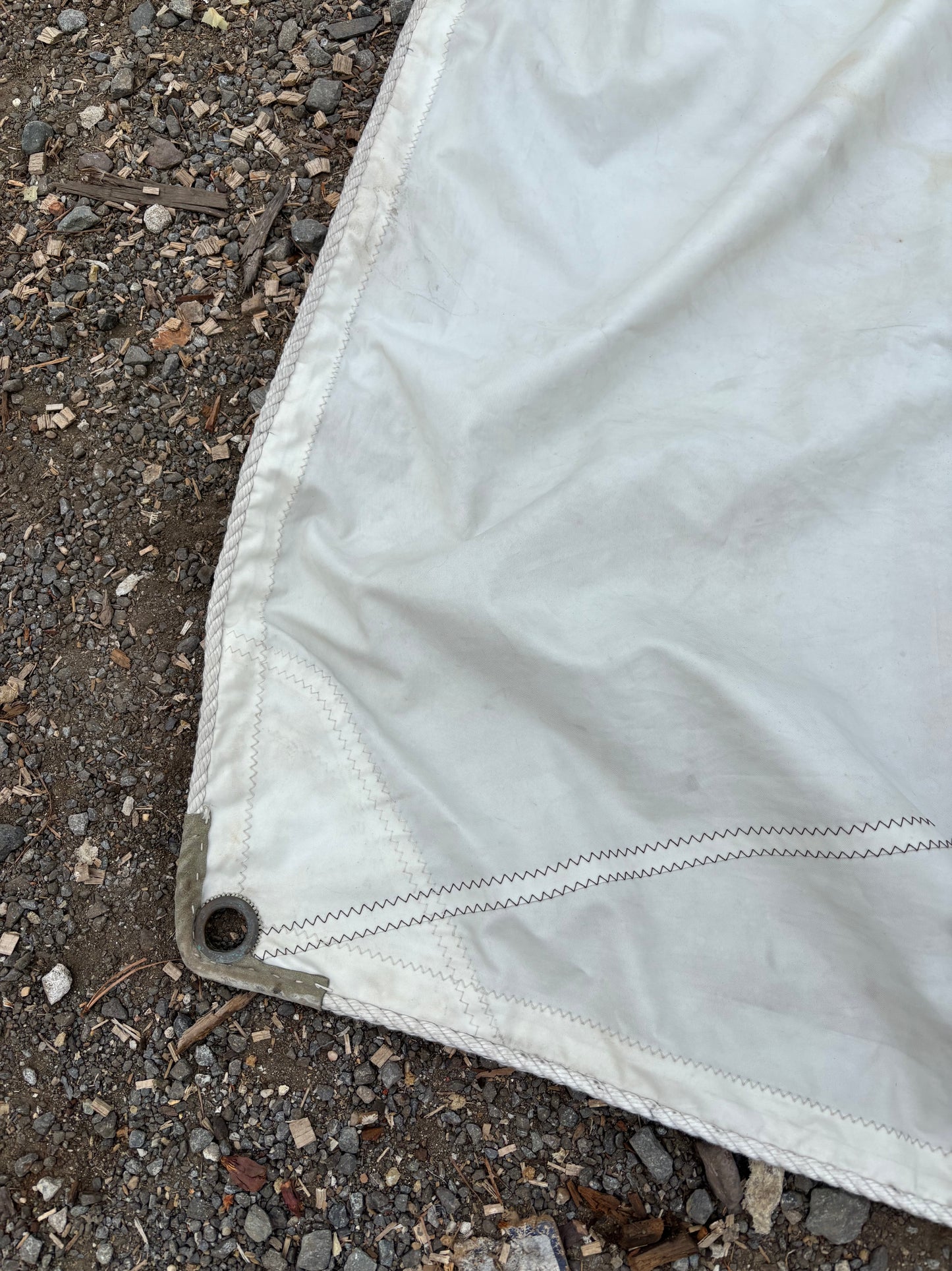 Close-up of a white tarp on a gravel surface