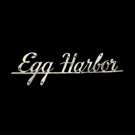Decorative sign with 'Egg Harbor' text on a black background