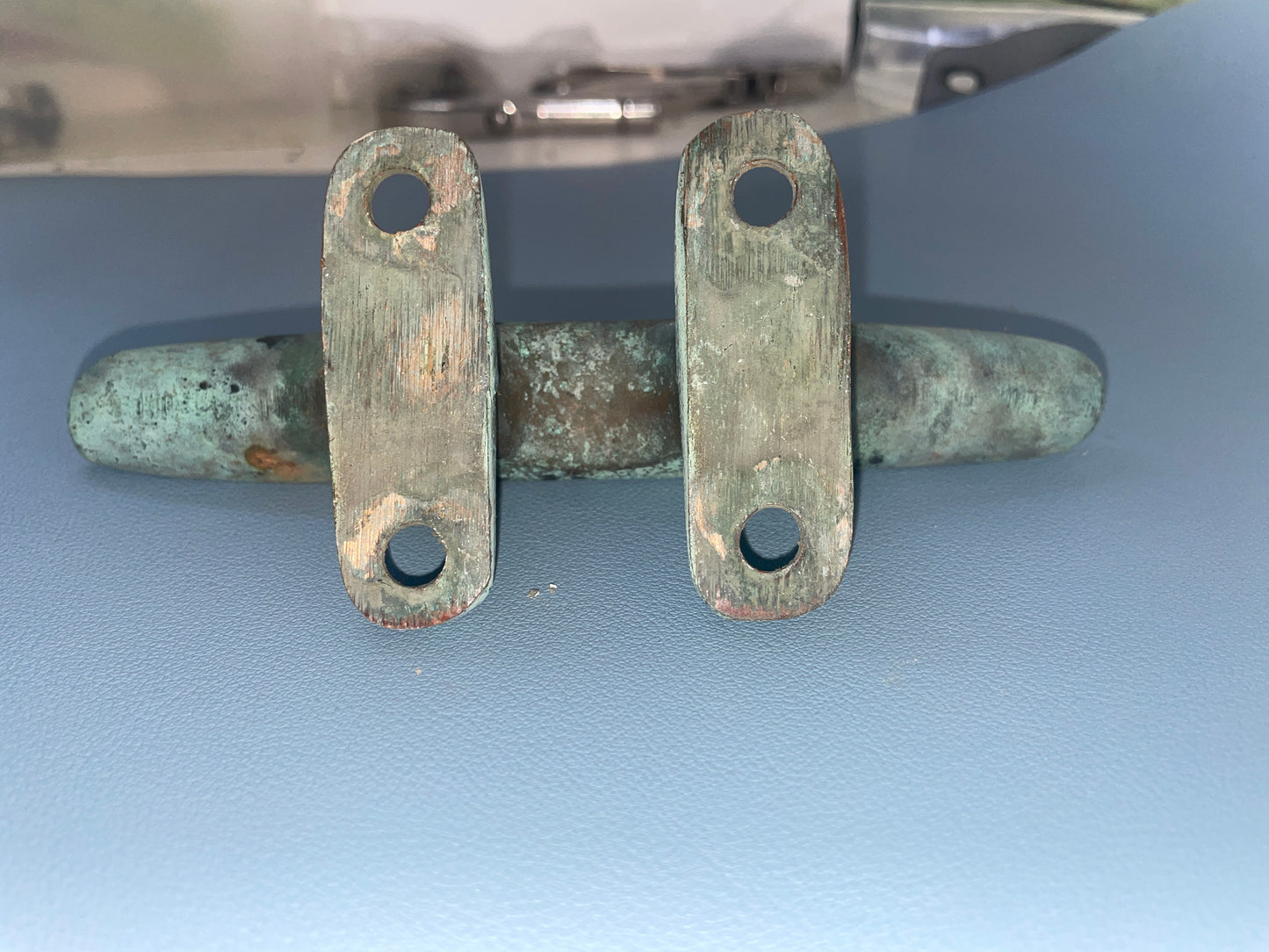 Pair of old-fashioned metal door handles on a blue background