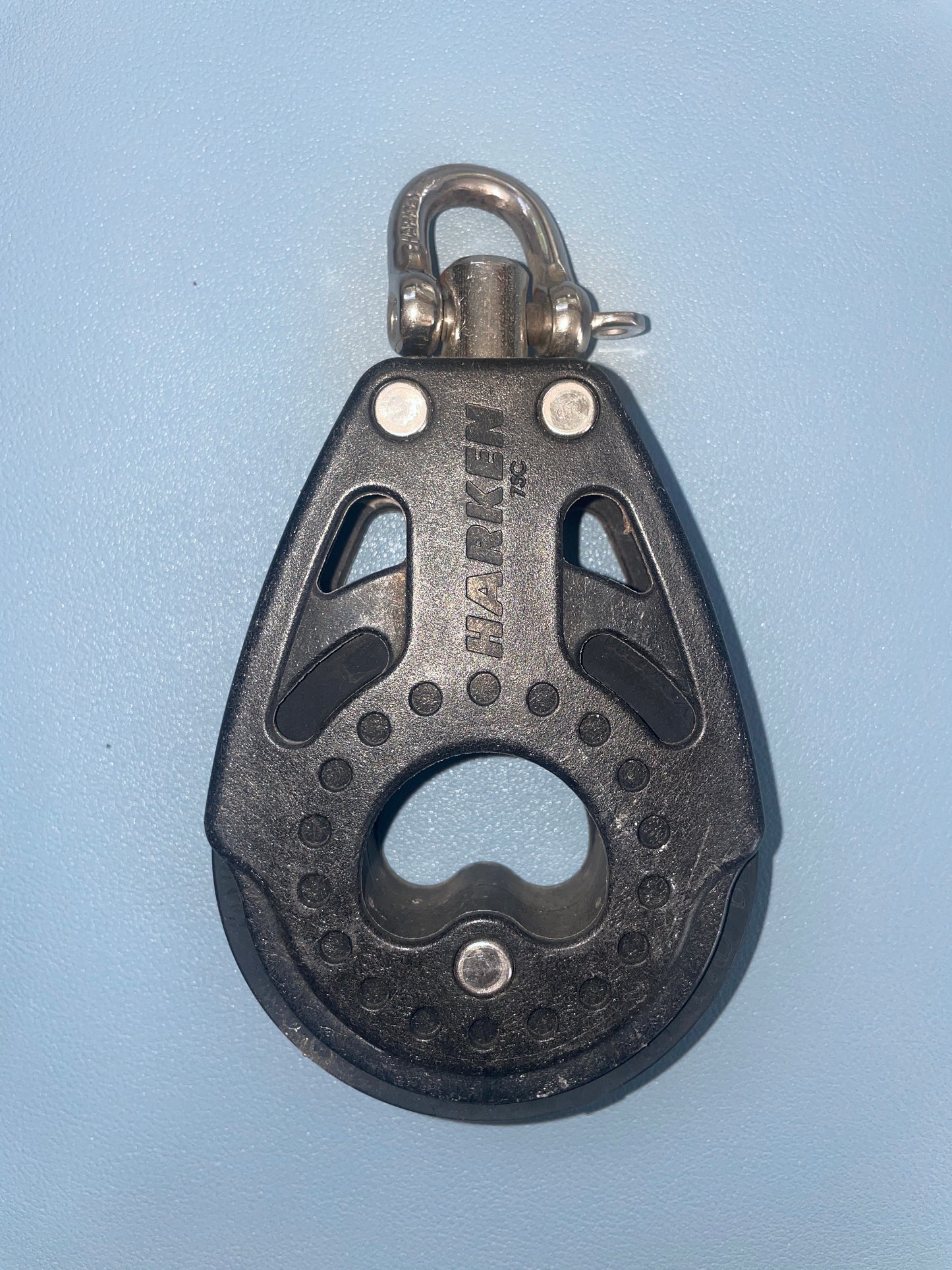 Multitool keychain with bottle opener on a light blue background