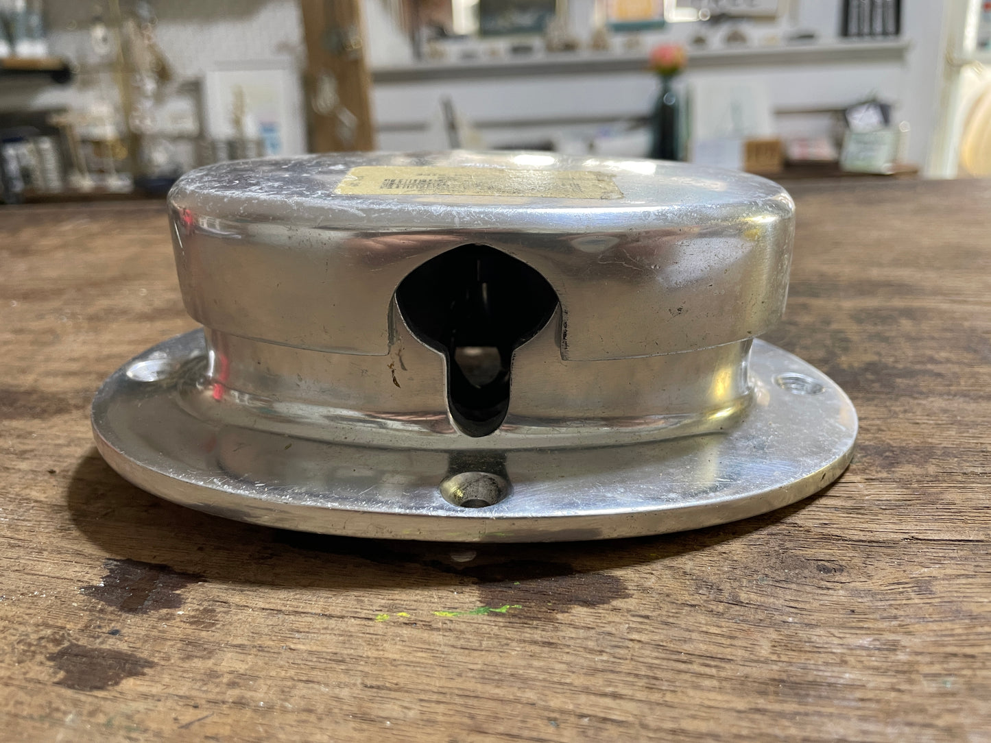 Metallic object on a wooden surface with a blurred background