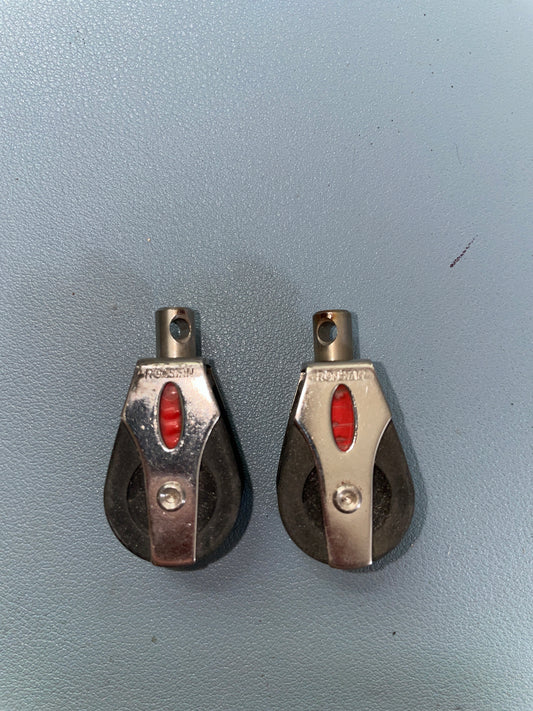 Two metal pulleys with red centers on a gray background