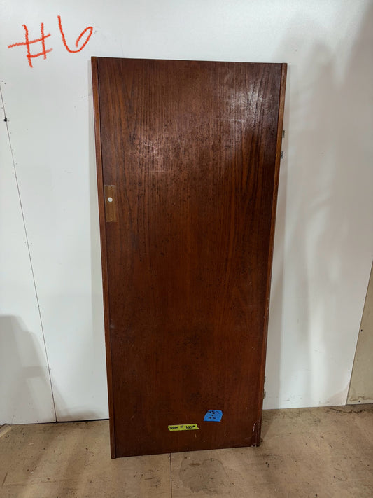 Wooden door against a white wall with a visible brand label.