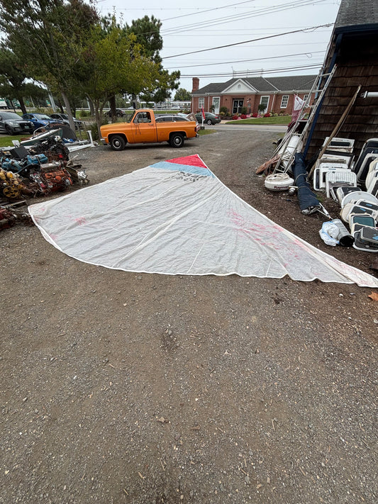 Street view with a yellow truck and various items on the side of the road.