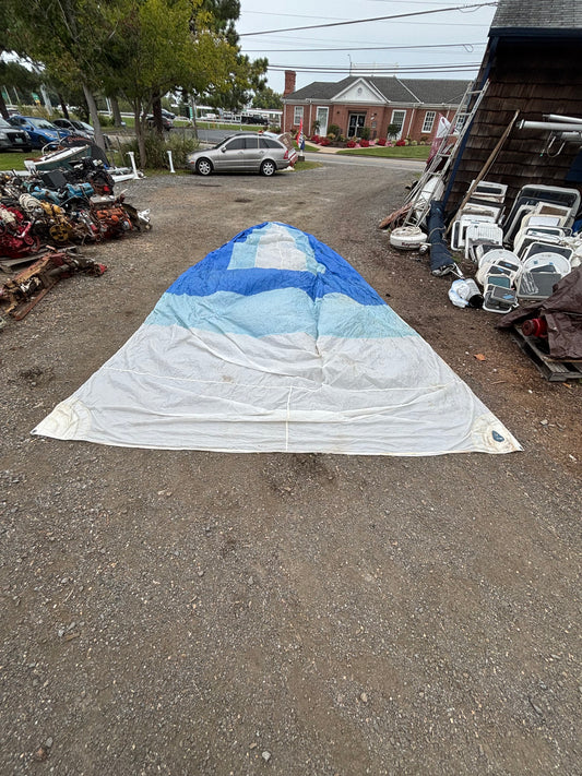 Large deflated sail on a street with buildings and cars in the background
