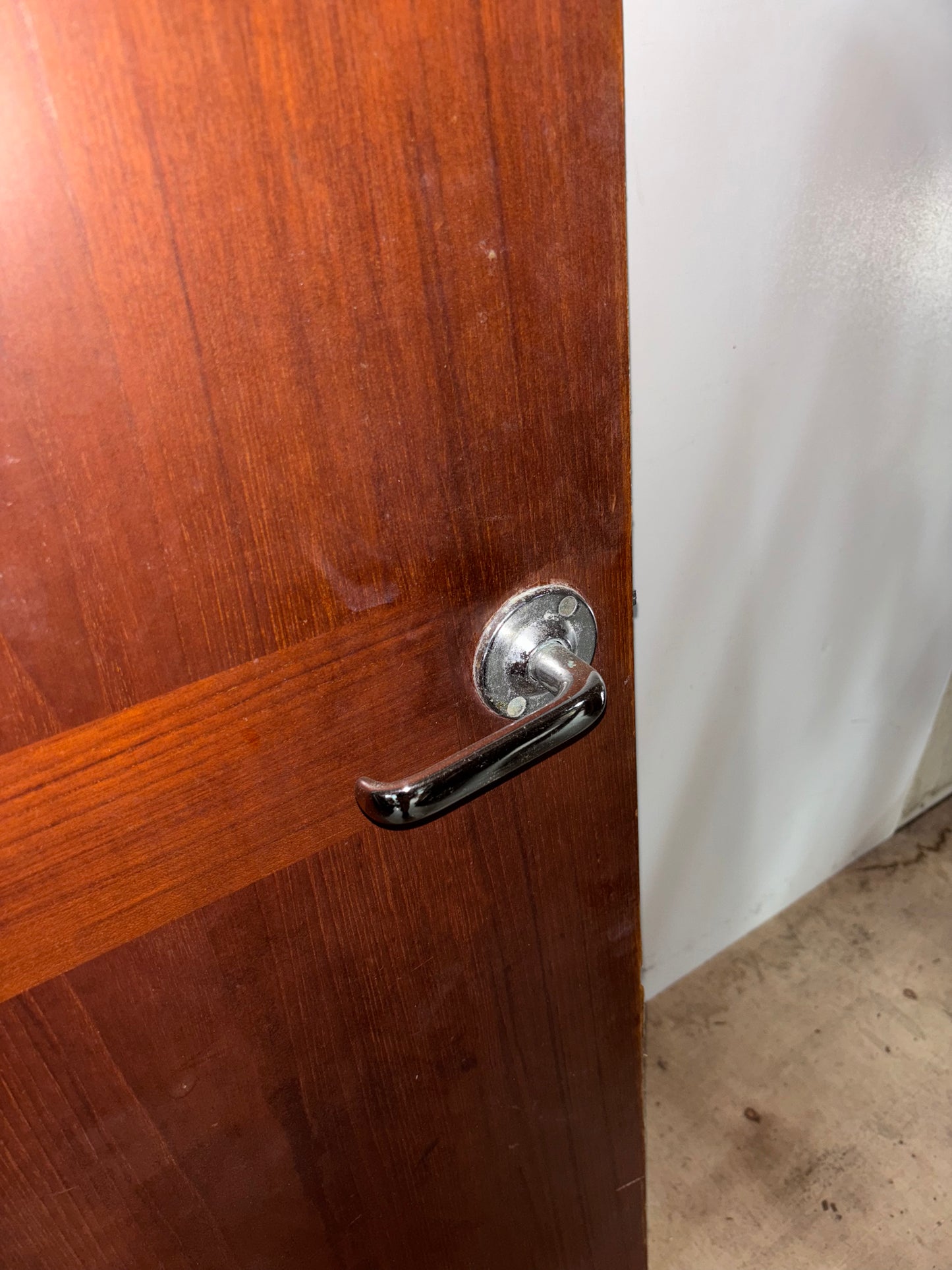 Wooden door with a metallic handle on a white background
