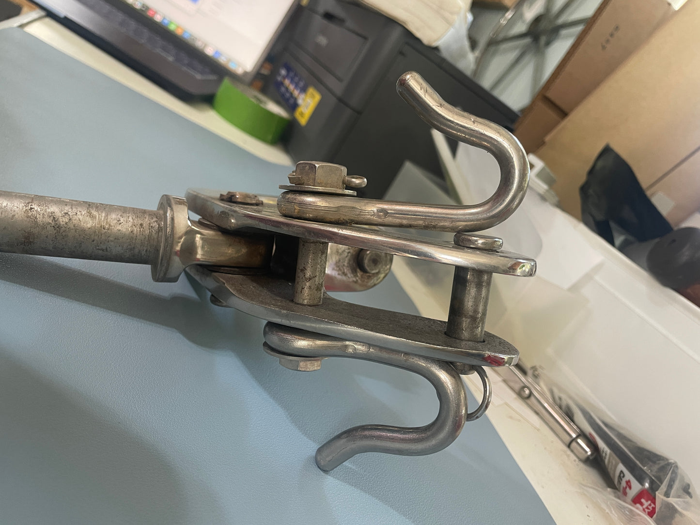 Metal clasp or lock mechanism on a white surface with a blurred background