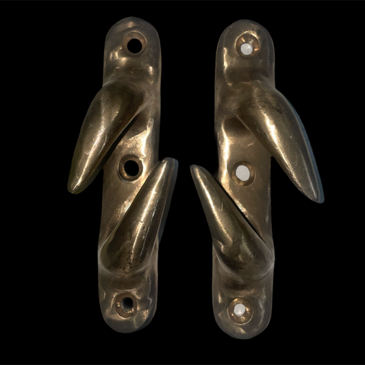 Four brass door handles on a black background
