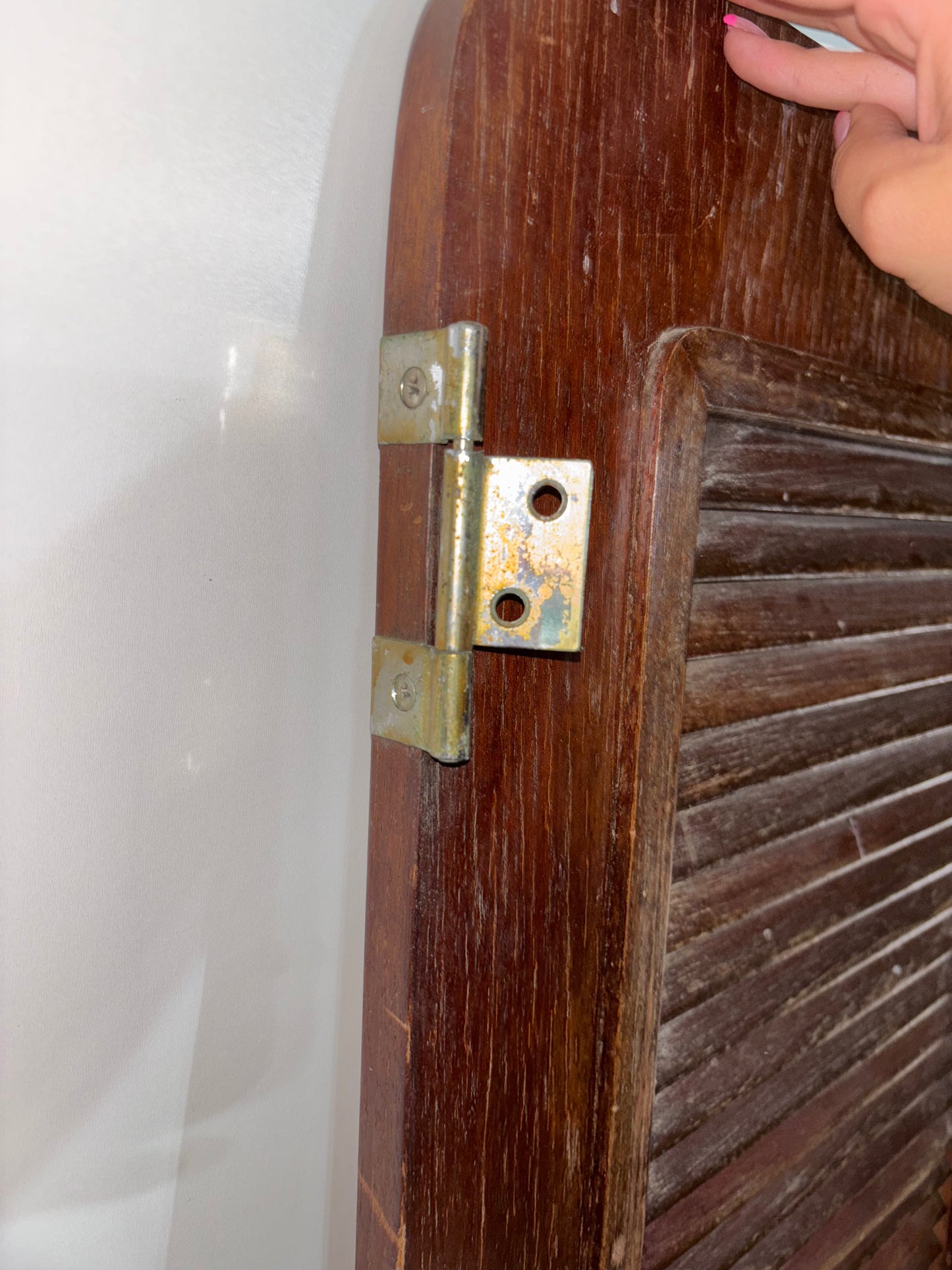 Wooden door with a metal hinge being adjusted against a white background