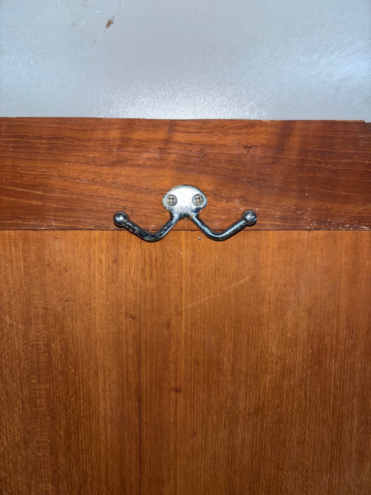 Wooden surface with a metal double hook on a white background