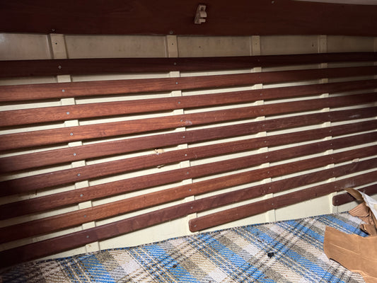 Wooden panel with metal brackets on a plaid fabric background