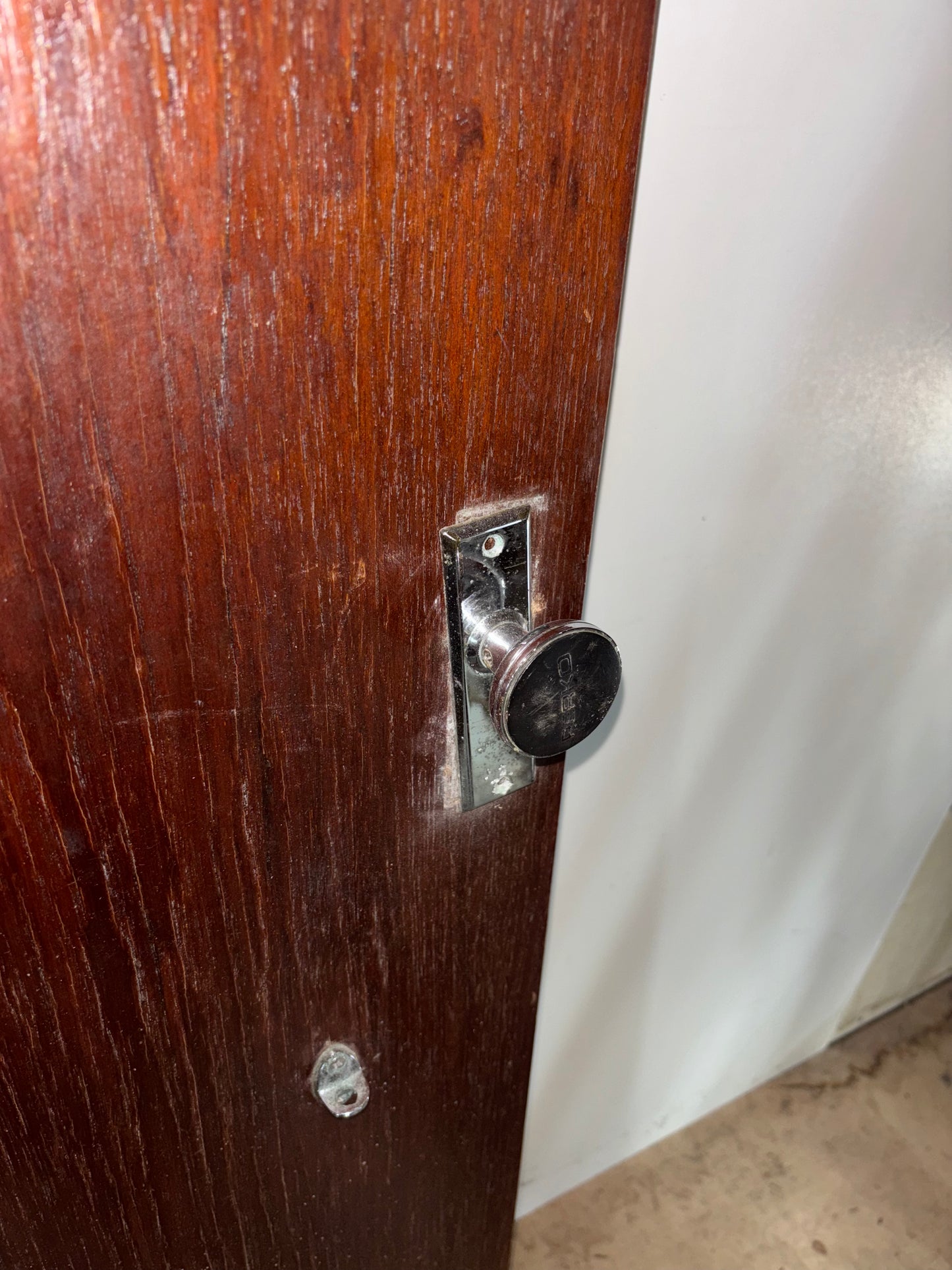 Wooden door with a metal handle and lock mechanism.