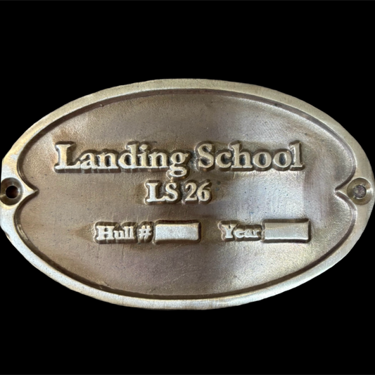 Metal plaque with 'Landing School LS 26' engraved on a black background
