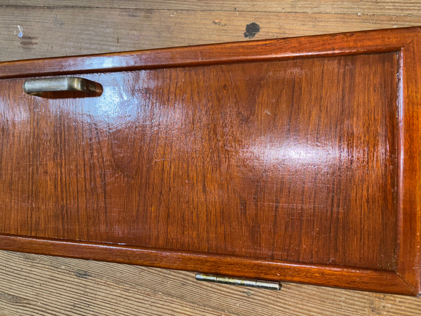 Wooden drawer with a metal handle on a wooden surface