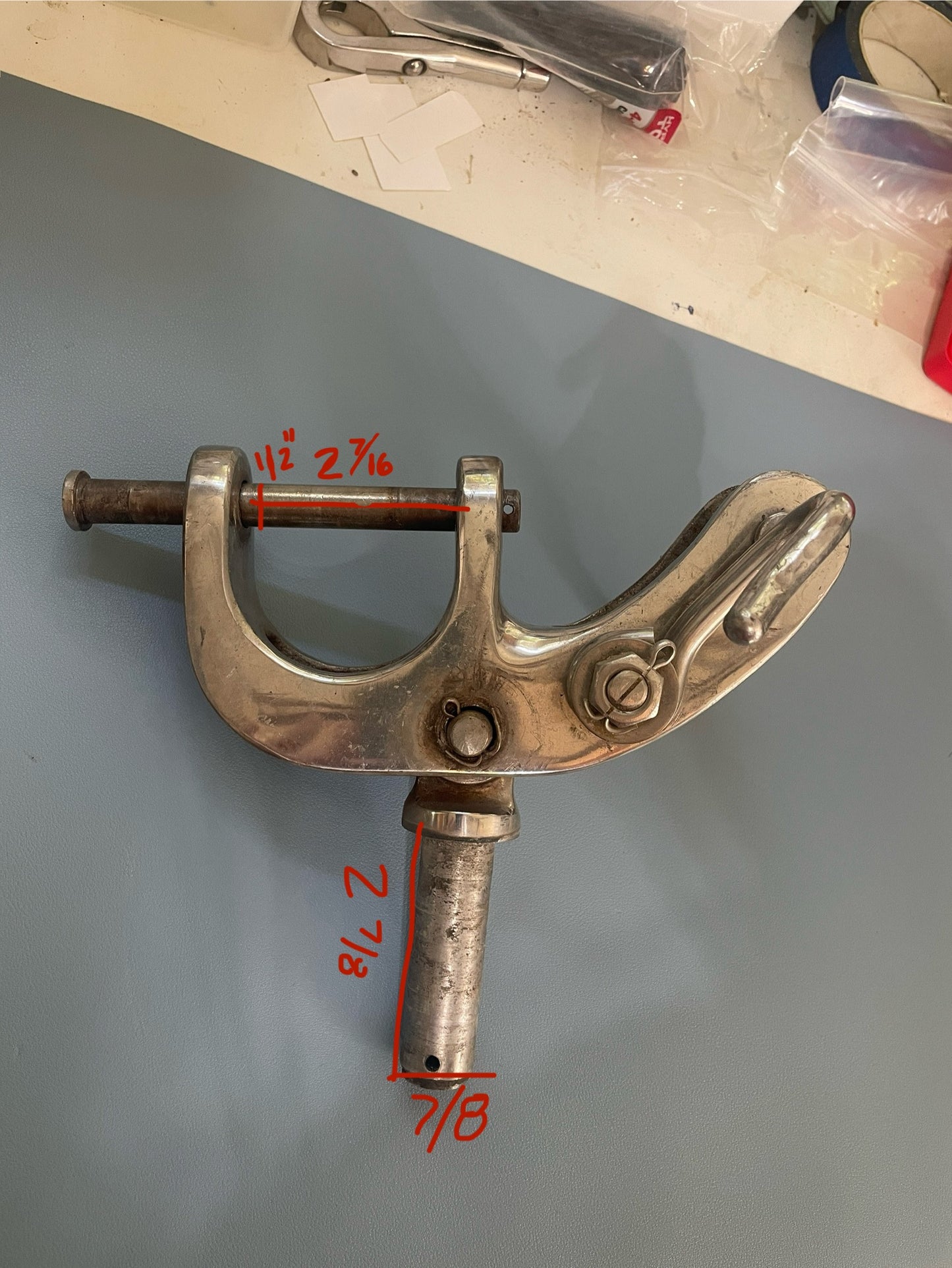 Metal clamping device with measurements on a gray surface
