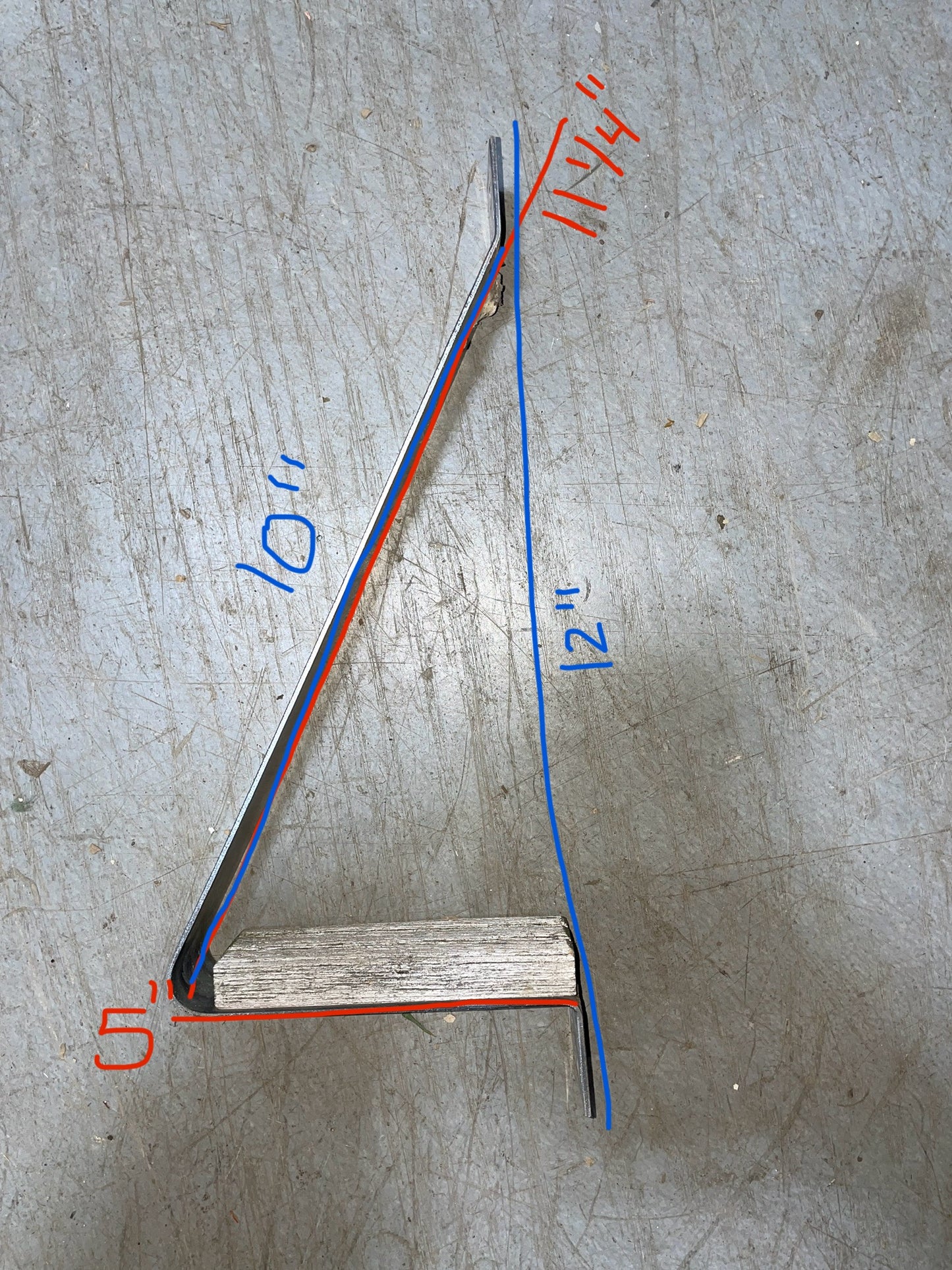 Wooden stick with red and blue measurements on a gray surface
