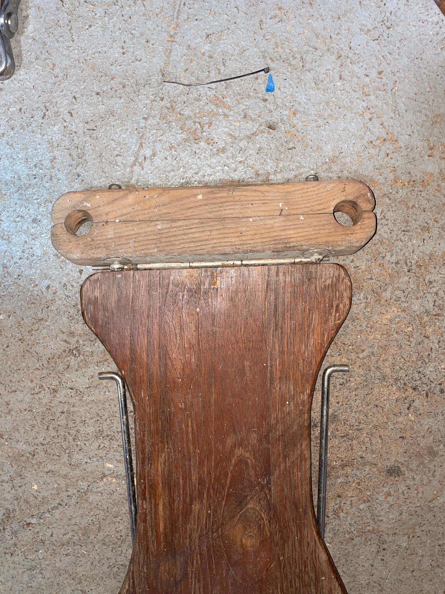 Wooden object with a handle on a concrete surface