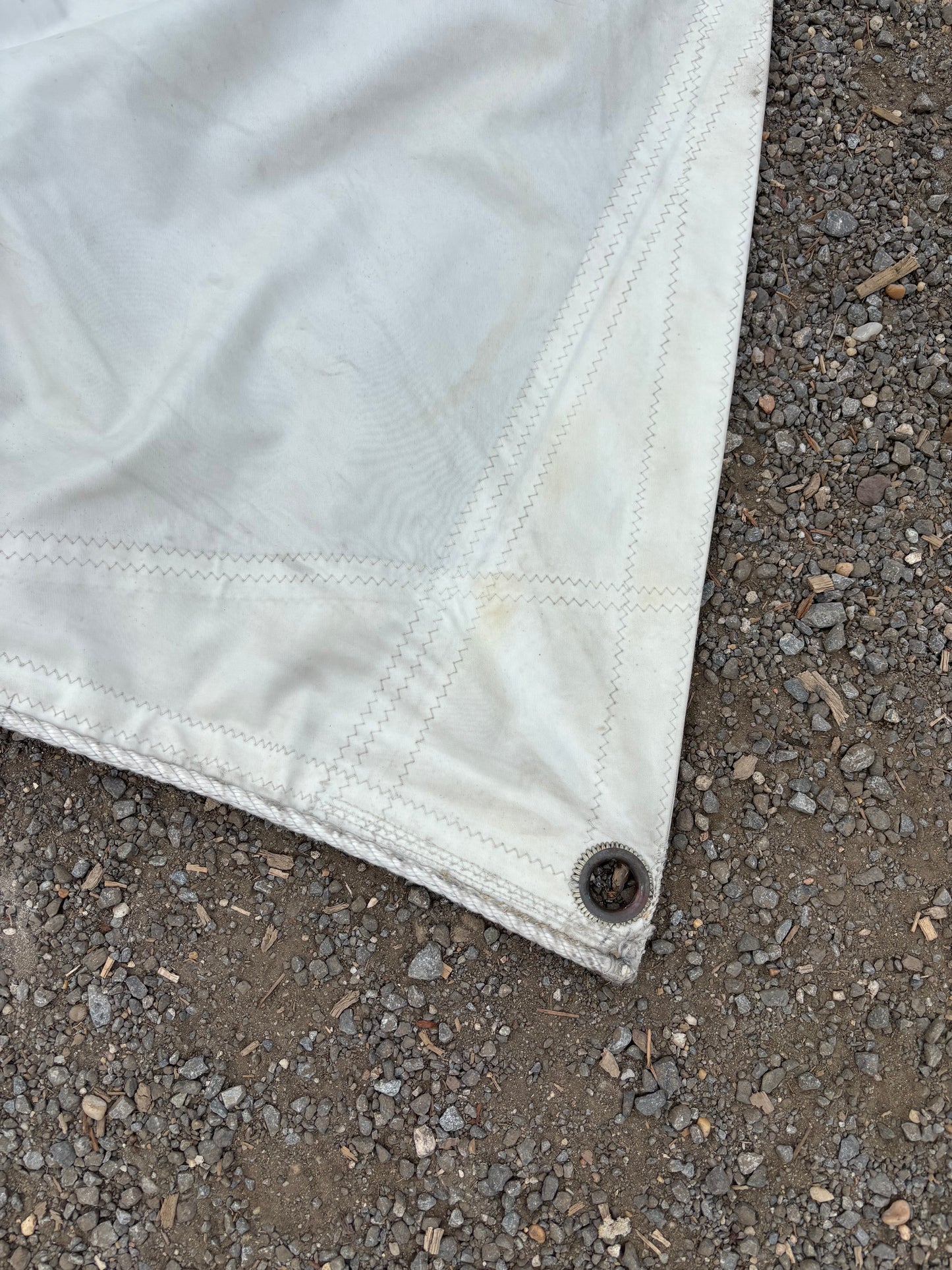 White fabric corner with a button on a textured gray surface