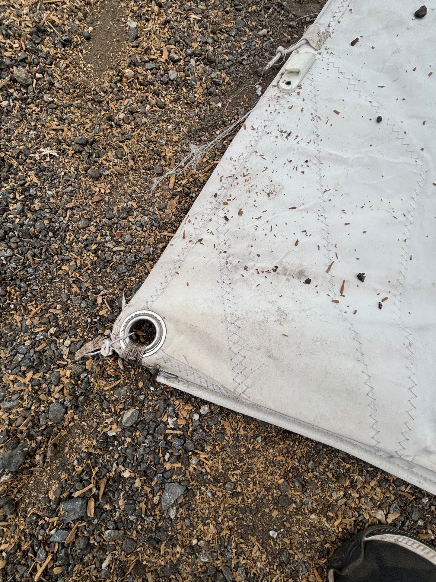 White tarp on a dirt and gravel surface