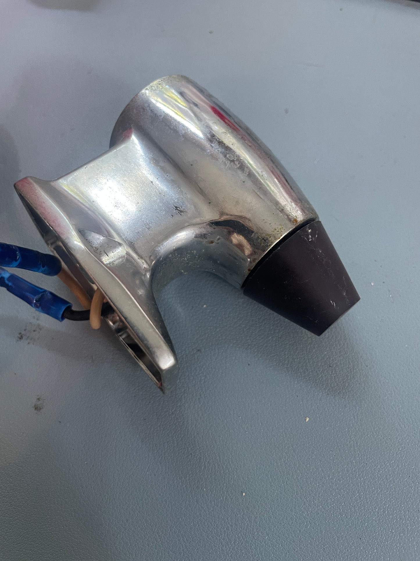 Metallic object with a black component on a gray background