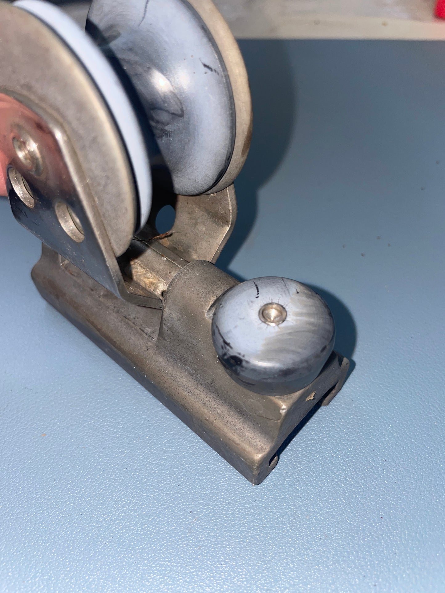 Metal roller with a wheel against a light blue wall