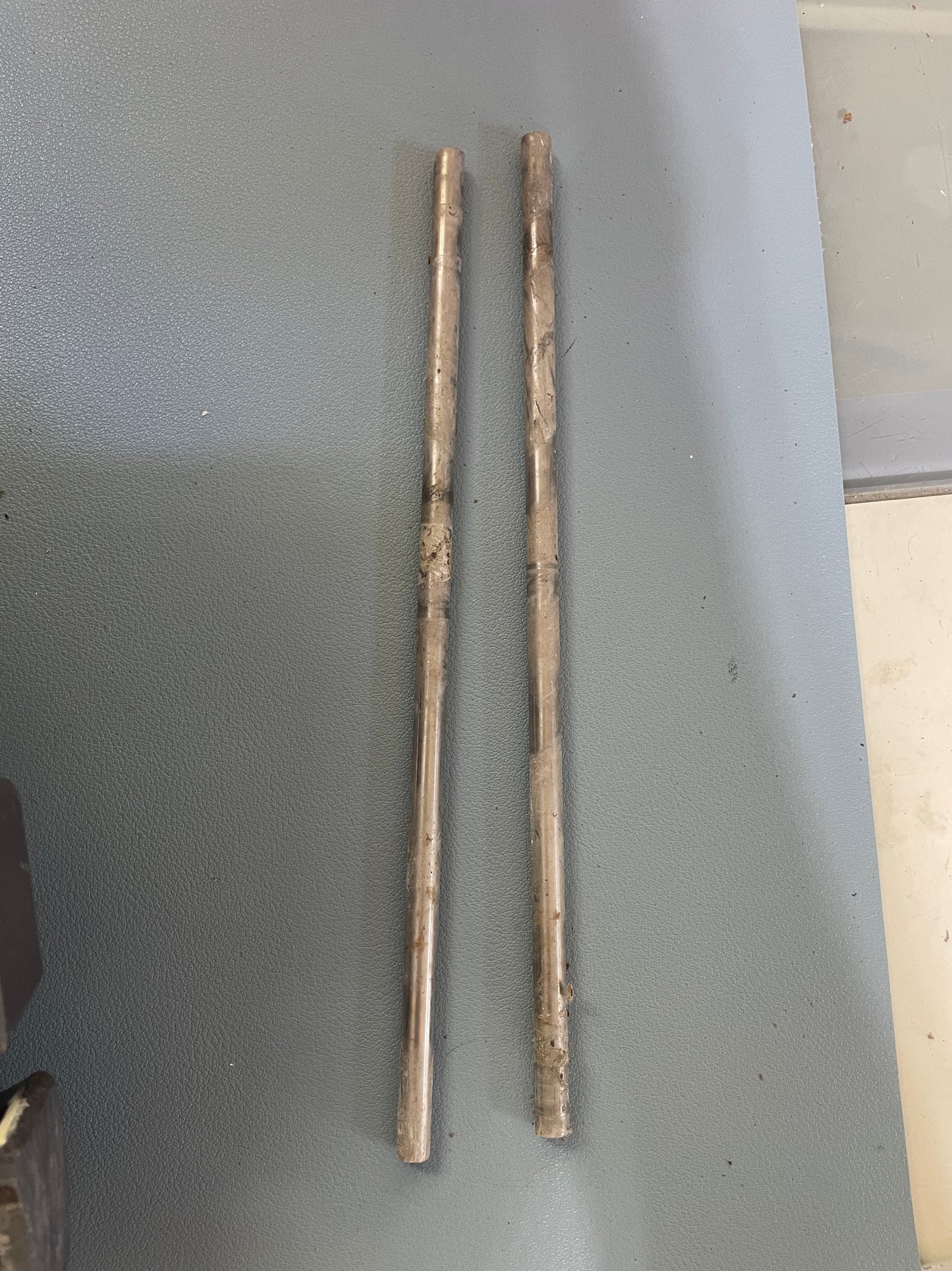Two wooden sticks on a gray surface