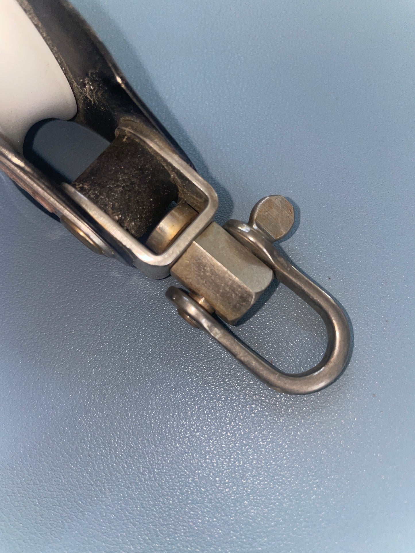 Metal carabiner with a spring clip on a light blue background