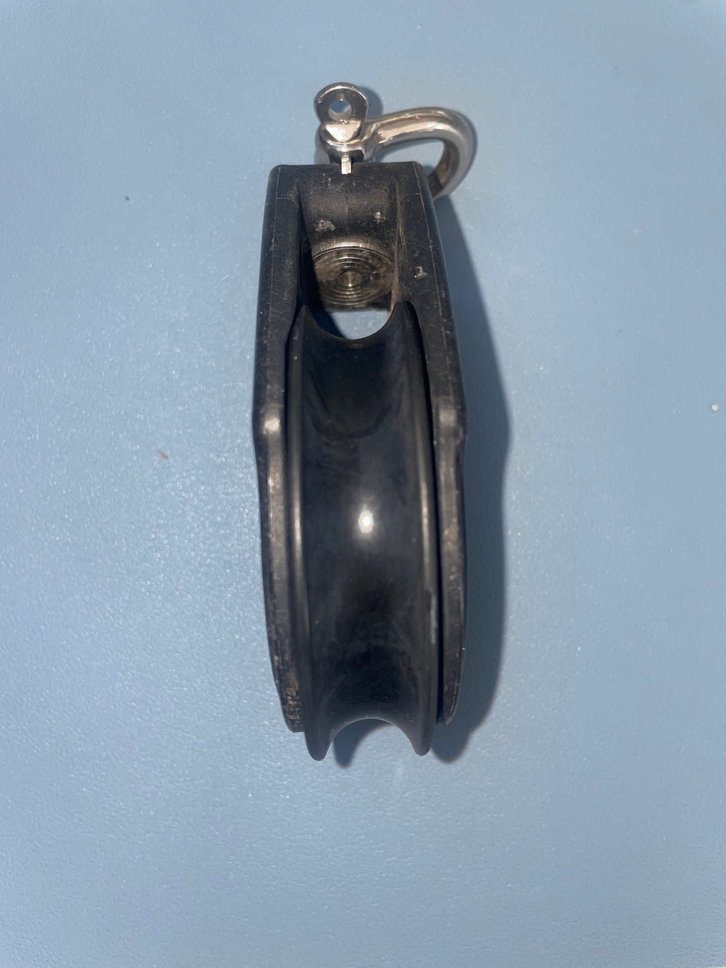 Black pulley system on a light blue background