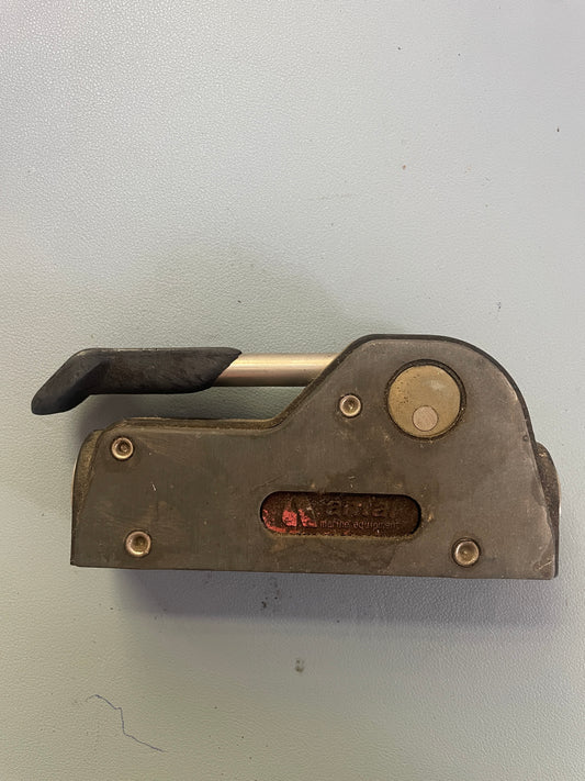 Metal tool with a lever on a light gray background