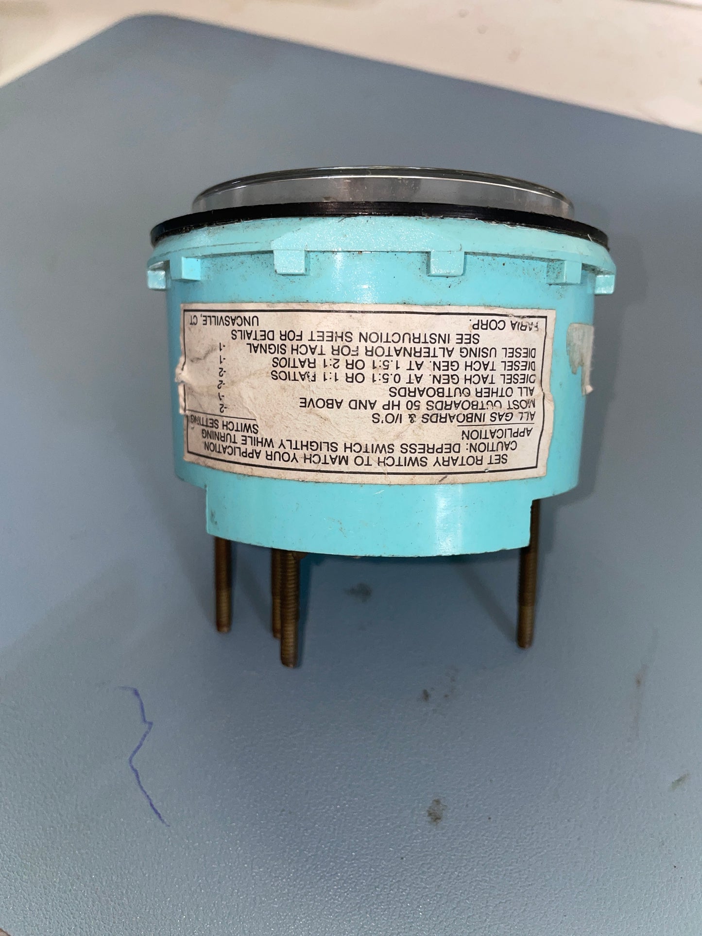 Turquoise electrical component with label on a gray background