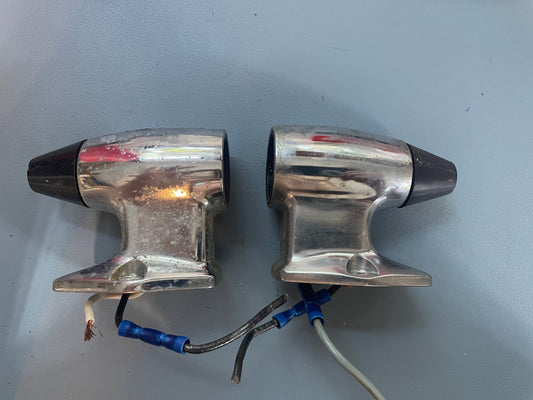 Two metallic car headlights with wiring on a gray background