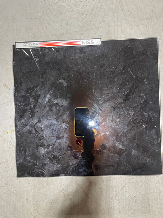 Vinyl record with a 'Kiss' album cover on a textured surface