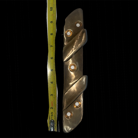 Metallic folding knife next to a tape measure on a black background