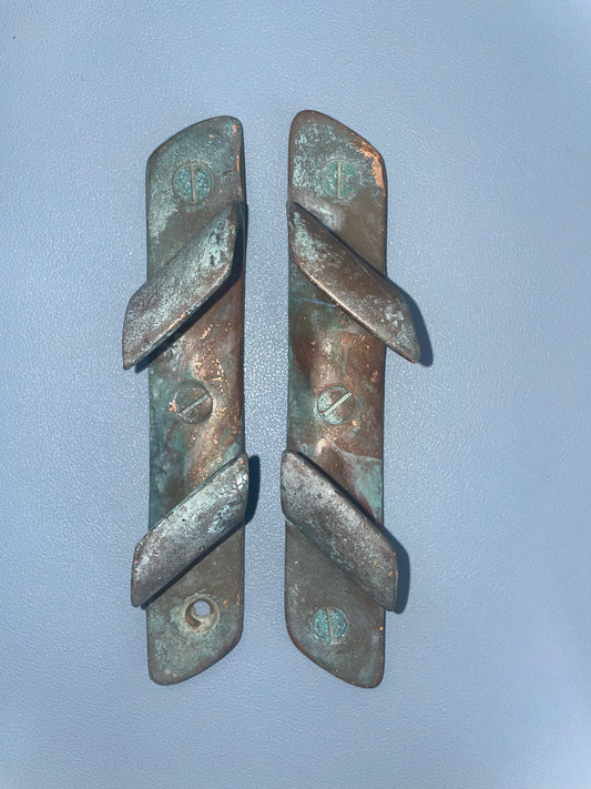 Two bronze tools on a light blue background