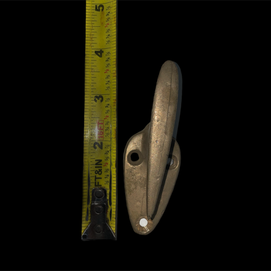 Metal cleat with a measuring tape on a black background