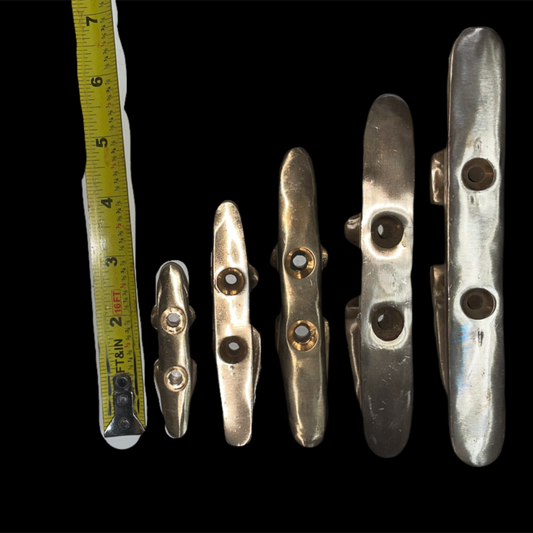 Set of metallic objects with a ruler for scale on a black background