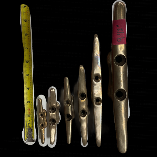Set of brass cleats with a tape measure on a black background