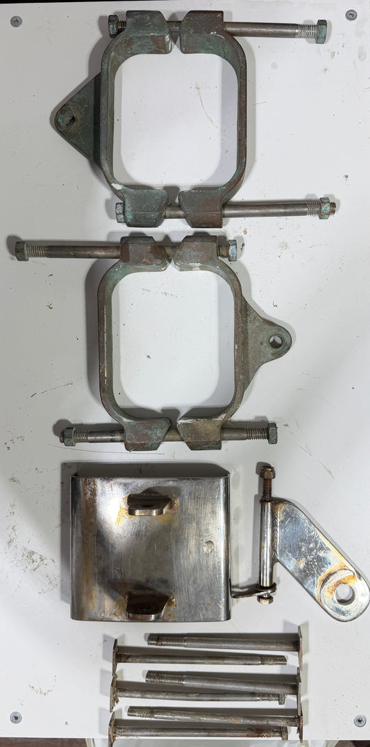 Metal clamps and tools on a white board with a wooden floor background